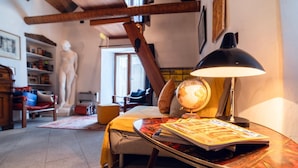 Een gezellige kamer met een bed, een bureau met een lamp, een wereldbol en een boekenkast.