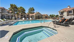 Una piscina con sillones de descanso, un jacuzzi y un edificio que dice 'Balm Spa'.
