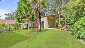 Una propiedad residencial con un césped cuidado, un garaje y un área exterior cubierta.