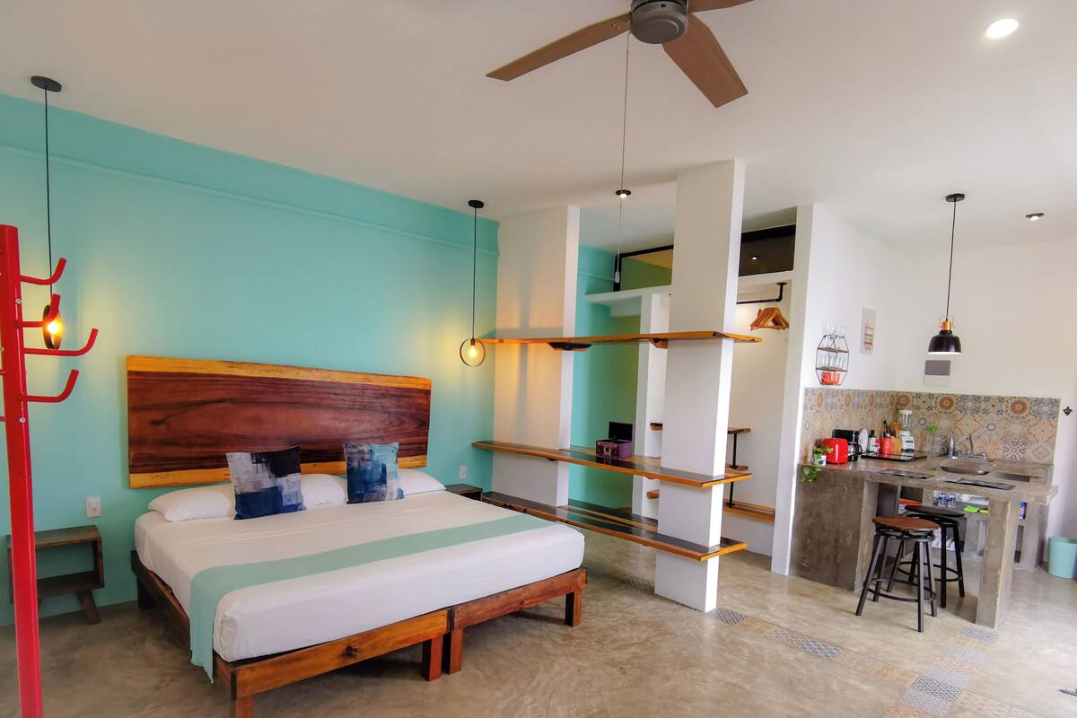 A modern bedroom with a wooden bed, a red wall-mounted rack, and a ceiling fan.