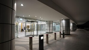 A modern hotel entrance with a revolving door, glass walls, and a curved ceiling. - Luxury hotel apartment with a charming view of the Nile and the pyramids Hilton (Cairo Governorate)