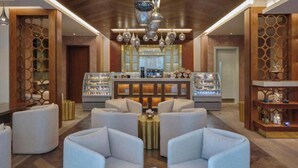 A lobby with a bar area, seating, and a decorative ceiling. - Luxury hotel apartment with a charming view of the Nile and the pyramids Hilton (Cairo Governorate)