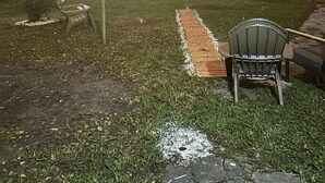 A backyard with a wooden deck, a chair, and string lights. - Riio Shores (Miami)