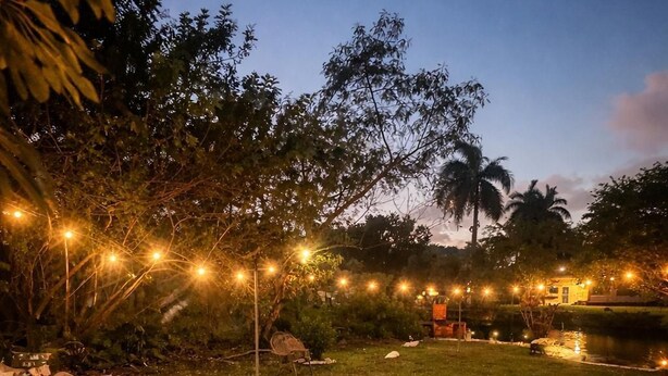 An outdoor area with string lights, a pathway, and a chair. - Riio Shores (Miami)