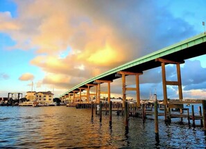 A waterfront pier with a green roof, wooden pillars, and a view of buildings and boats in the background. - North Breeze, lake view with heated Pool (North Fort Myers)