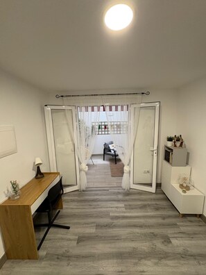 A room with a desk, chair, and a view through a doorway to another room with a bed and curtains. - Apartment CASA ÑEÑE by KHOUSE VACATION (Puerto de la Cruz)