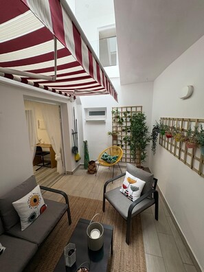 A compact living space with a dining area, a seating area with a coffee table, and a balcony with a striped awning. - Apartment CASA ÑEÑE by KHOUSE VACATION (Puerto de la Cruz)