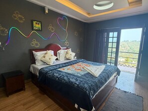 A bedroom with a bed, a nightstand, a view through a window, and decorative wall art.