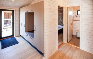 Une pièce comprenant une grande armoire, un lit, une petite salle de bain et une porte donnant sur l’extérieur.