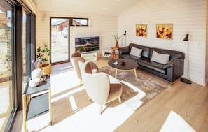 A modern living room with a sofa, chairs, a coffee table, and artwork on the walls.