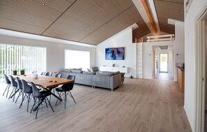 A modern interior with a dining area, sofa, TV, and a staircase. - Gorgeous home in Sæby with sauna (Sæby)