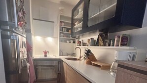 A compact kitchen with a sink, countertop, and cabinets. - Cozy apartment in a vibrant neighborhood  with fast internet (Skopje)