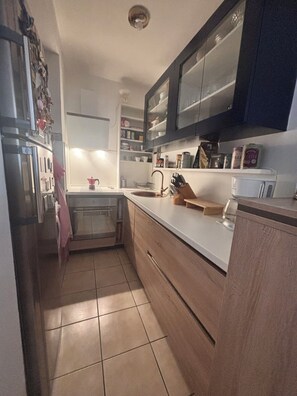 Cocina compacta con pileta, encimera y alacenas.