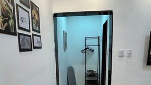 Ein Flur mit einer Tür zu einem Zimmer, einem Wandhaken und gerahmten Bildern an der Wand.
