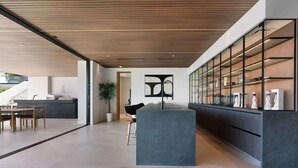 Ein modernes Interieur mit einer Küche, einem Essbereich und einer großen Vitrine.