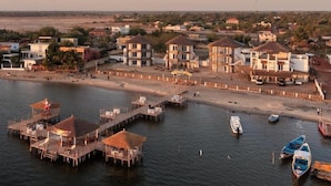A coastal area with a pier, boats, and buildings.