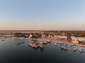 A coastal town with a marina, buildings, and a clear sky.