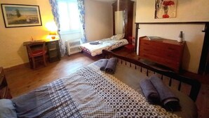 A bedroom with a bed, a chair, a desk, a dresser, and a painting on the wall. - Roquepoix - A green stopover in the Gers (Mirepoix)