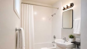 A bathroom with a shower, bathtub, sink, and toilet. - Tumbleweed Motel  (Cache Creek)