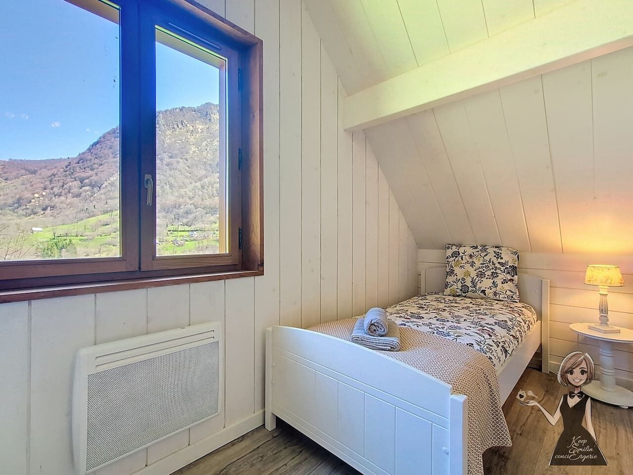 Une chambre à coucher avec un lit, une fenêtre, un radiateur et une table de chevet avec une lampe.