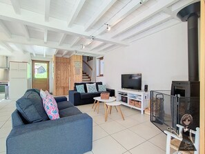 Ett modernt vardagsrum med en soffa, en tv och en öppen spis.