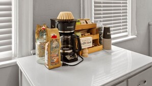 A coffee station with a coffee maker, a bag of coffee beans, a glass jar, a wooden box, and a stack of coffee cups. - Double Living, Patio BBQ, Massage & South Side Fun (Pittsburgh)