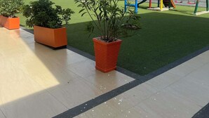 A playground with a slide and swings, surrounded by potted plants and a building with a brick wall. - Spacious 3-bedroom apartment in perfect Barranquilla with AC (Barranquilla)