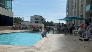 A swimming pool with tiled flooring, surrounded by a fence with colorful decorations. - Spacious 3-bedroom apartment in perfect Barranquilla with AC (Barranquilla)