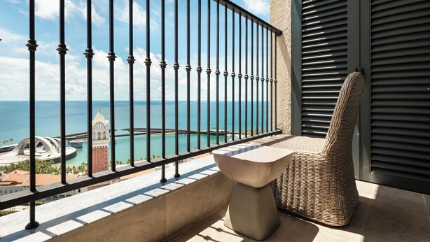 Ein Balkon mit Meerblick, einem Stuhl und einem Tisch.