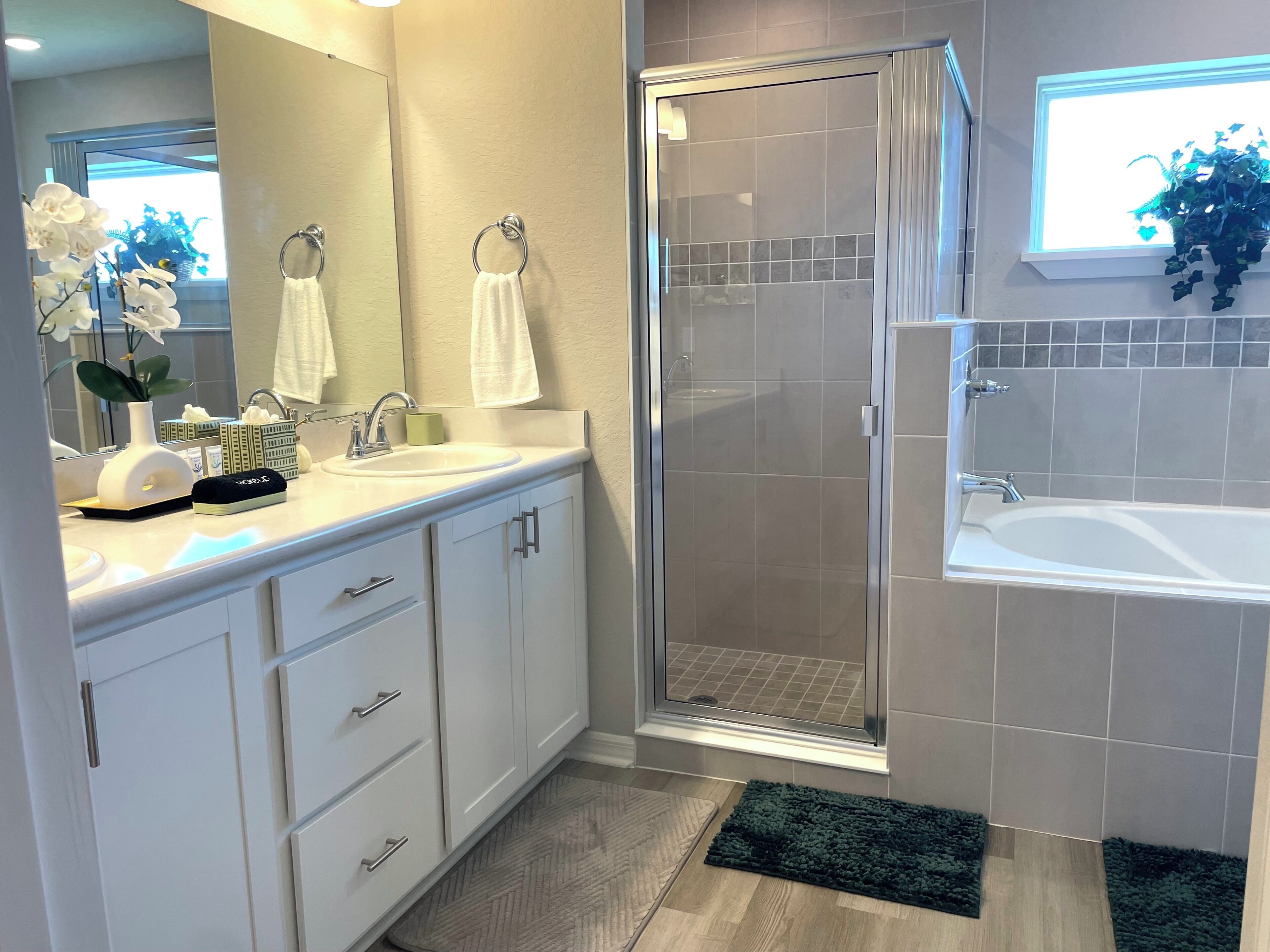 Une salle de bain moderne équipée d’une douche, d’une baignoire et d’un meuble-lavabo avec un miroir.