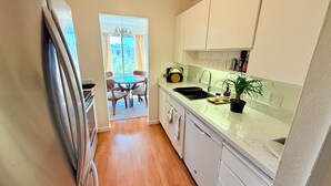 A narrow kitchen with a dining area in the background, a sink, and a potted plant on the counter. - Elevator, Private Parking
Balcony, CalKingBed
Entire rental unit in Wanut creek (Walnut Creek)