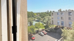 A view through a window with a mesh screen, featuring a parking lot, a building with multiple windows, and greenery in the background. - Elevator, Private Parking
Balcony, CalKingBed
Entire rental unit in Wanut creek (Walnut Creek)