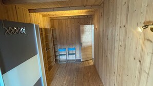 A narrow hallway with wooden walls and a wooden floor, leading to a door at the end. - Superb apartment in a country house (Passy)