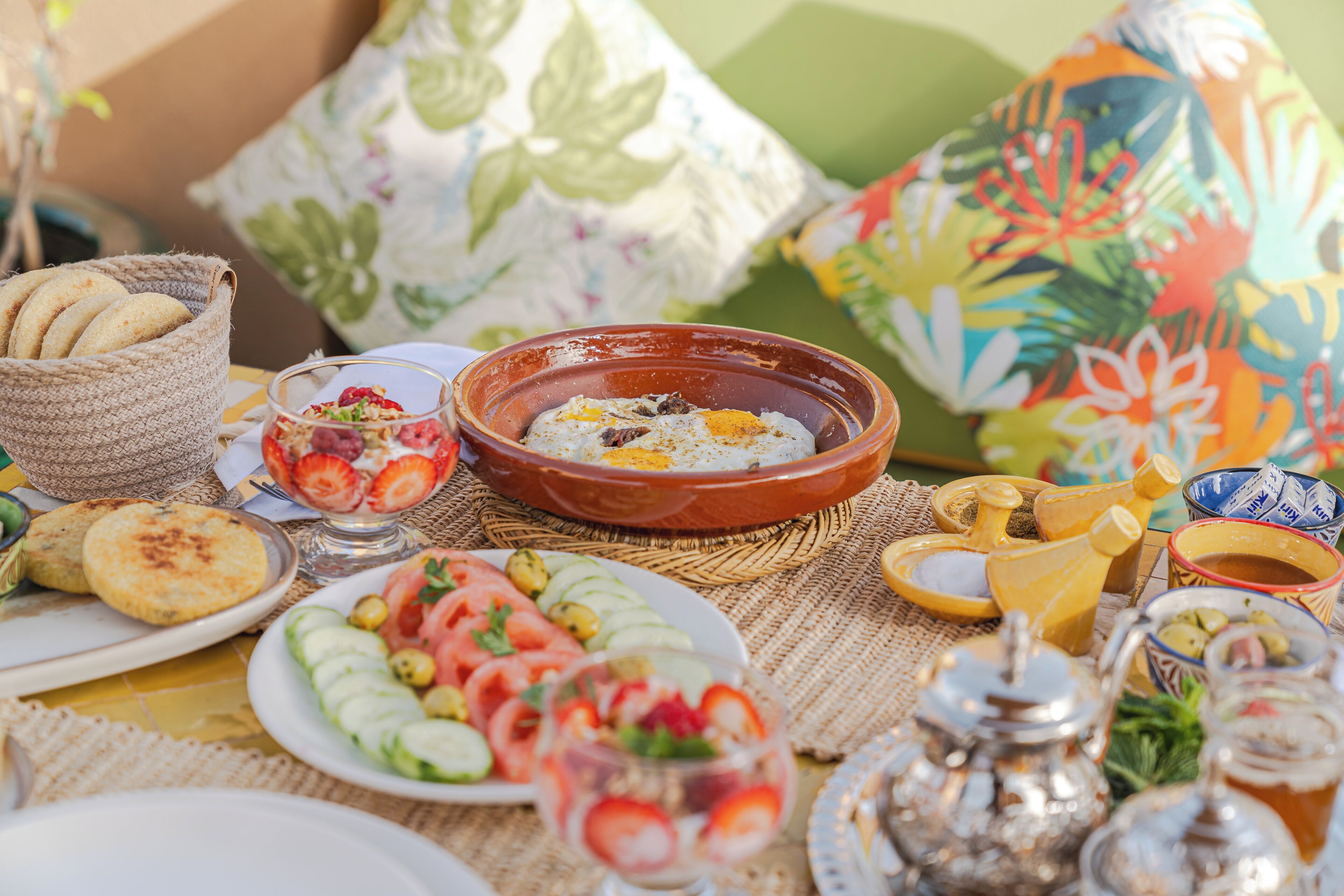 Una mesa dispuesta con diversos platos, como una ensalada, pan y un tazón de arroz.