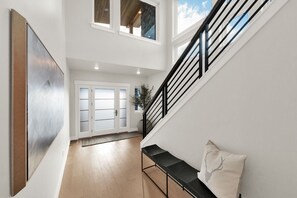 Ein modernes Interieur mit Treppe, einer Bank und einer Tür zu einem anderen Raum.