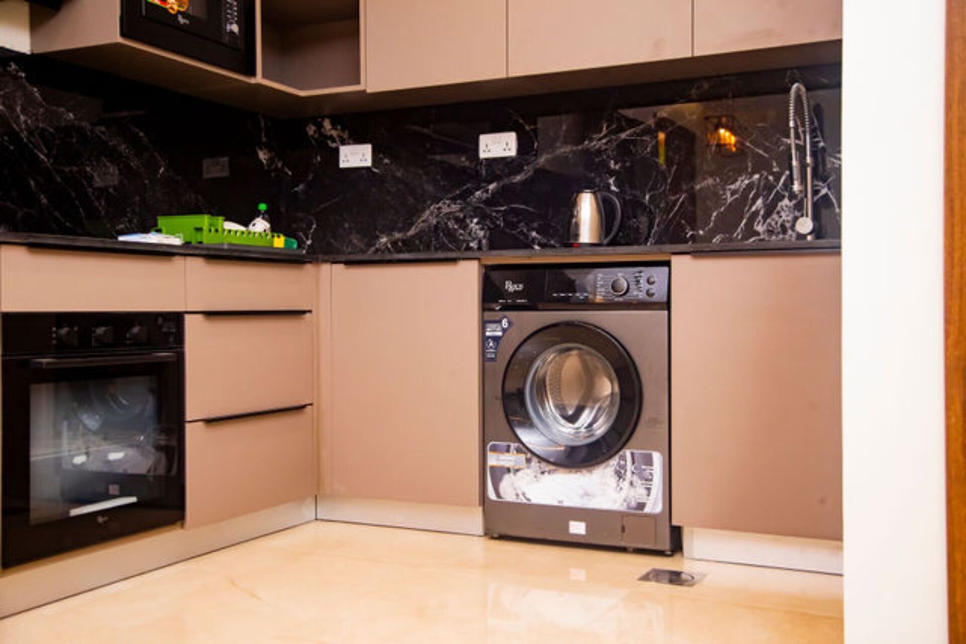 A compact kitchen with a built-in washer and dryer, a microwave, and a small oven.