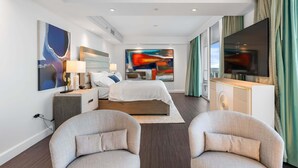 A modern hotel room with a bed, two armchairs, a desk, and artwork on the walls. - Sorrento 512 (Miami Beach)