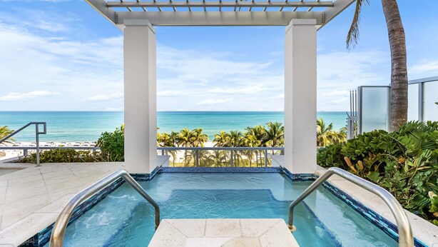 A pool with a view of the ocean, a pergola, and palm trees. - Sorrento 512 (Miami Beach)