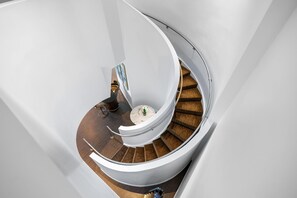 Eine Wendeltreppe mit Holzbodenstufen und weißen Wänden.