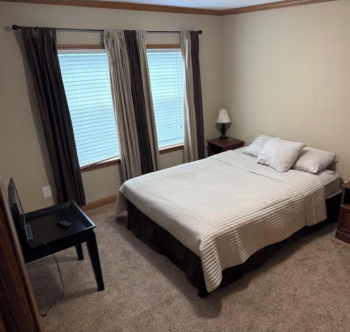 Une chambre à coucher avec un lit, un bureau et une lampe.