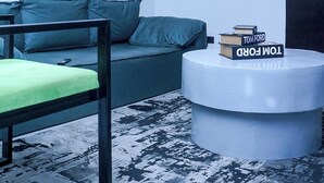 Una sala de estar moderna con un sofá, una mesa redonda de centro y un equipo de aire acondicionado en la pared.