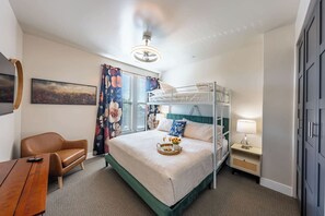A bunk bed room with a desk, chair, and a painting on the wall. - Cozy Main St Stay | King Bed + Loft Bed | Sleeps 3 (Pleasant Grove)