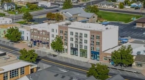 A multi-story building with a flat roof, large windows, and a parking lot in front. - King Suite with Twin Loft – Family Friendly (Pleasant Grove)