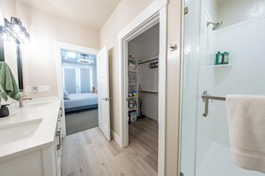Ein modernes Badezimmer mit Duschkabine aus Glas, einem weißen Waschbecken und einem Handtuchhalter.