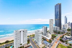 A coastal cityscape with high-rise buildings, a beach, and a clear blue sky. - Sky-High Luxury - Sun City (Gold Coast)