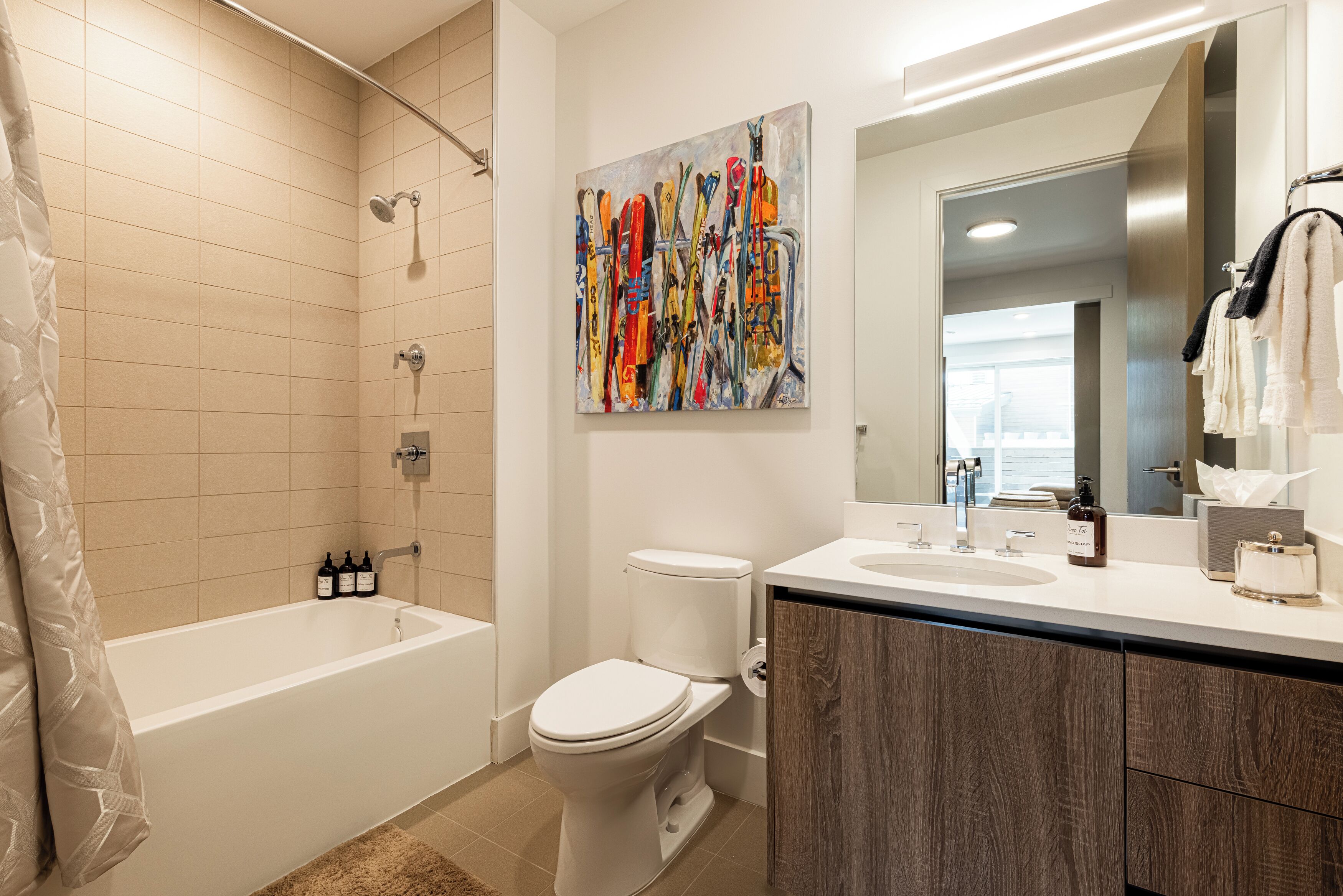 Une salle de bain moderne avec une baignoire, des toilettes et un grand miroir.