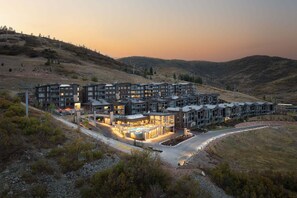 A modern multi-story hotel with a pool area, surrounded by hilly terrain. - Experience luxury at Park City Apex 207, a 3-bedroom ski-in/ski-out condo in Canyons Village. (Park City)