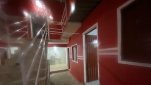 A red-walled corridor with a staircase and a door. - Villa Callegaro Hotel Capivari SP (Capivari)