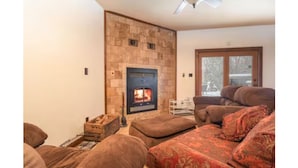 A living room with a fireplace, a sofa, and a window.