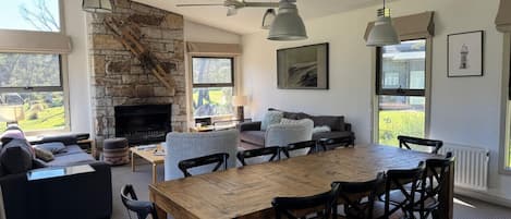 A spacious living area with a fireplace, a dining table, and comfortable seating.